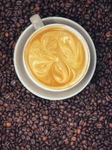 Overhead view of a coffee cup resting on a bed of coffee beans